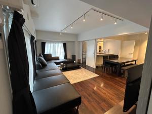 NIYS apartments 74 type في طوكيو: غرفة معيشة مع أريكة وطاولة