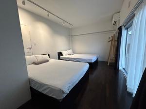 a room with two beds and a window at NIYS apartments 74 type in Tokyo