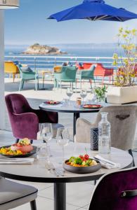 - une table avec des assiettes de nourriture et des verres à vin dans l'établissement Hôtel Valdys Thalasso & Spa - la Baie, à Douarnenez