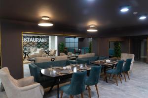 a restaurant with tables and chairs and a sign that reads startup at Dora Hotel in Shymkent