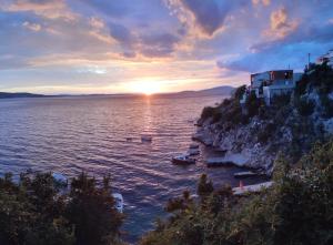 a sunset over a body of water with boats at Appartement Blue Lagune 4 Sterne in Prizna