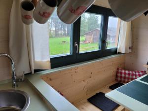 eine Küche mit einem Waschbecken und einem Fenster in der Unterkunft Woidwogn in Mauth