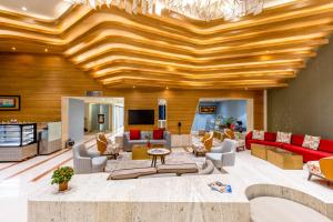 a living room with a wooden ceiling at Citadel Sarovar Portico Bengaluru in Bangalore