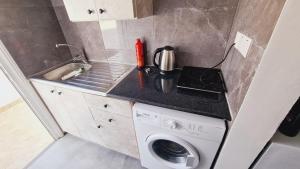 eine kleine Küche mit einer Waschmaschine und einem Waschbecken in der Unterkunft STAY Nissi Gusto Studio 1 in Ayia Napa