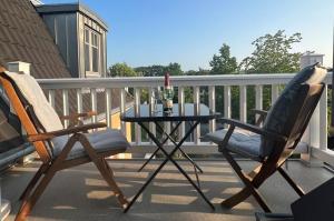 2 stoelen en een tafel op een balkon bij Villa Balticum, Whg 5 in Zingst