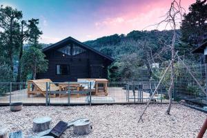 eine Blockhütte mit einem Picknicktisch und einem Spielplatz in der Unterkunft VILLA ATAMI -Maruta- in Atami