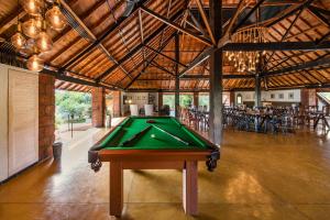 a pool table in a room with tables and chairs at SaffronStays Satori Aves, Ultra Luxe Cottages On 8 Acres Estate, By The Mulshi Lake in Mulshi
