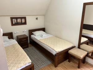 ein kleines Zimmer mit 2 Betten und einem Spiegel in der Unterkunft DuoD in Niš