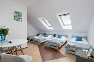 Pokój z 3 łóżkami, stołem i krzesłami w obiekcie Sleeply Pensjonat Złotniki we Wrocławiu