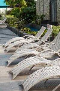 een rij witte stoelen naast een zwembad bij Studio condo for rent in Bacolod
