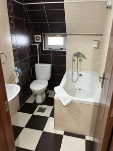 ein kleines Bad mit einem WC und einer Badewanne in der Unterkunft DuoD in Niš