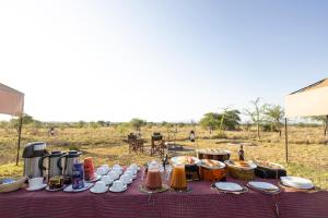 een tafel met voedsel erop in een veld bij Africa Safari Serengeti Ikoma Camping in Serengeti