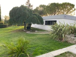 un bâtiment blanc dans une cour avec un arbre dans l'établissement Villa Paradise, à Gémenos