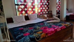 ein Bett mit einer Decke drauf mit einer Schlange drauf in der Unterkunft KANAK RESIDENCY in Chālsa Mahābāri