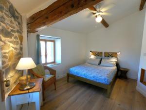 a bedroom with a bed and a table and a chair at La Petite Romance - Gîte 3 étoiles in Siran