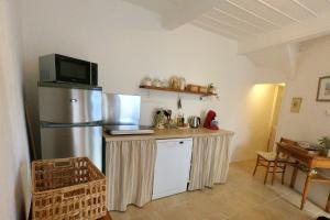 a kitchen with a counter with a refrigerator and a microwave at La Petite Romance - Gîte 3 étoiles in Siran