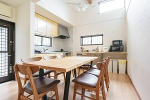 uma cozinha com uma mesa de madeira e cadeiras em VILLA ATAMI -Nagomi- em Atami