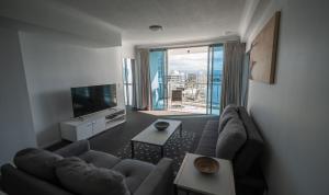 een woonkamer met een grote bank en een televisie bij Chevron Renaissance - Resort Style Living by Gold Coast Premium in Gold Coast