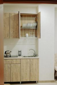 a kitchen with wooden cabinets and a sink at Flat in Petrosani in Petroşani