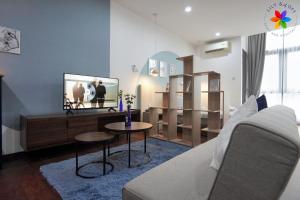 a living room with a couch and a tv at Lily and Loft - Queensville @ Kuala Lumpur - Netflix in Kuala Lumpur