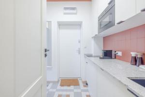 eine Küche mit weißen Arbeitsflächen und einer weißen Tür in der Unterkunft Modern apartment in City Centre in Danzig