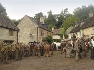 um grupo de pessoas em pé em torno de uma aldeia com um cavalo em Battens Farm Cottages B&B em Yatton Keynell