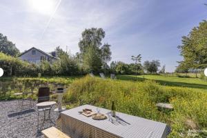 een patio met een tafel en stoelen en een veld bij HirschenHof in Léglise