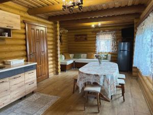 ein Esszimmer mit einem Tisch in einer Hütte in der Unterkunft Сонячний Лаз in Poljana