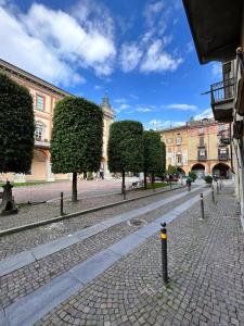 a cobblestone street in a city with trees and buildings at La Loggia dei Mercanti in Cuneo