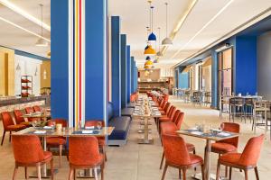 赫尔格达Neverland City Hurghada - Pickalbatros的餐厅设有桌椅和蓝色的墙壁
