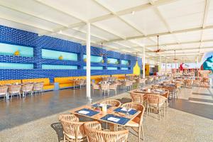 赫尔格达Neverland City Hurghada - Pickalbatros的餐厅里有桌椅，墙壁是蓝色的。