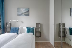 um quarto com 2 camas e almofadas azuis em RentPlanet - Port Popowice em Breslávia