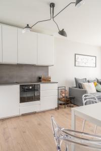 a living room with white cabinets and a couch at RentPlanet - Port Popowice in Wrocław