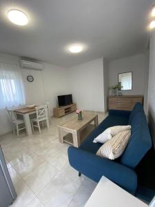un soggiorno con divano blu e tavolo di Apartments D&D a Osobjava
