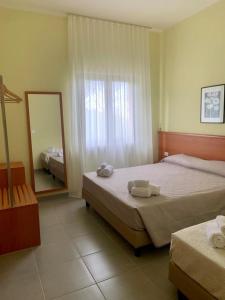 a hotel room with two beds and a mirror at Pianisi Albergo in SantʼElia a Pianisi