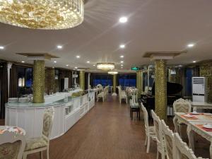 a restaurant with a bar and tables and chairs at La Renta Premium Cruise in Ha Long