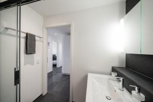 un bagno bianco con lavandino e doccia di Schöne Parterrewohnung in Matten a Matten