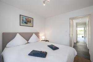 una camera da letto con un letto bianco con due asciugamani sopra di Schöne Parterrewohnung in Matten a Matten