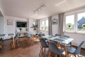 jadalnia ze stołami, krzesłami i oknami w obiekcie Sleeply Pensjonat Złotniki- dom dla 18 osób we Wrocławiu