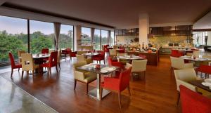 a dining room with tables and chairs in a restaurant at Four Points by Sheraton New Delhi, Airport Highway in New Delhi