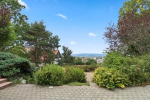 a garden with trees and bushes and a bench at Appartement paisible avec terrasse in Domdidier