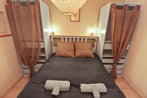 Appartement paisible avec terrasse في Domdidier: سرير في غرفة عليها منشفتين