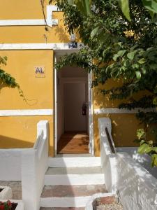 une entrée à un bâtiment avec un mur jaune dans l'établissement Casa do Cristo Rei II, à Almada