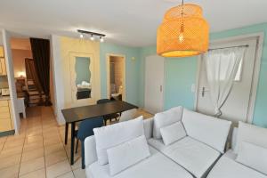een woonkamer met een witte bank en een tafel bij Appartement paisible avec terrasse in Domdidier