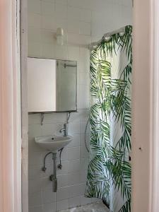 La salle de bains est pourvue d'un rideau de douche et d'un lavabo. dans l'établissement Casa do Cristo Rei II, à Almada