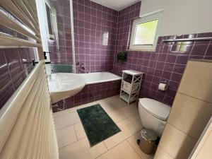a purple tiled bathroom with a toilet and a sink at Altes Bauernhaus in der Natur in Detmold +23 photos