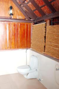 a bathroom with a toilet and wooden walls at Elephant Courtyard- A Heritage Homestay in Alleppey