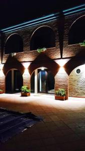 a brick building with potted plants and lights at Relais Galatea in Montecorvino Pugliano