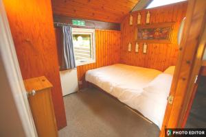 a small room with a bed and a window at Iona Cabin in Taynuilt