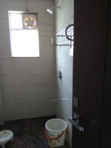 a bathroom with a toilet and a window and a bucket at Goroomgo Viren Holiday Home Agra in Agra